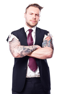 Businessman in a suit with no sleeves and tattoo on his arms